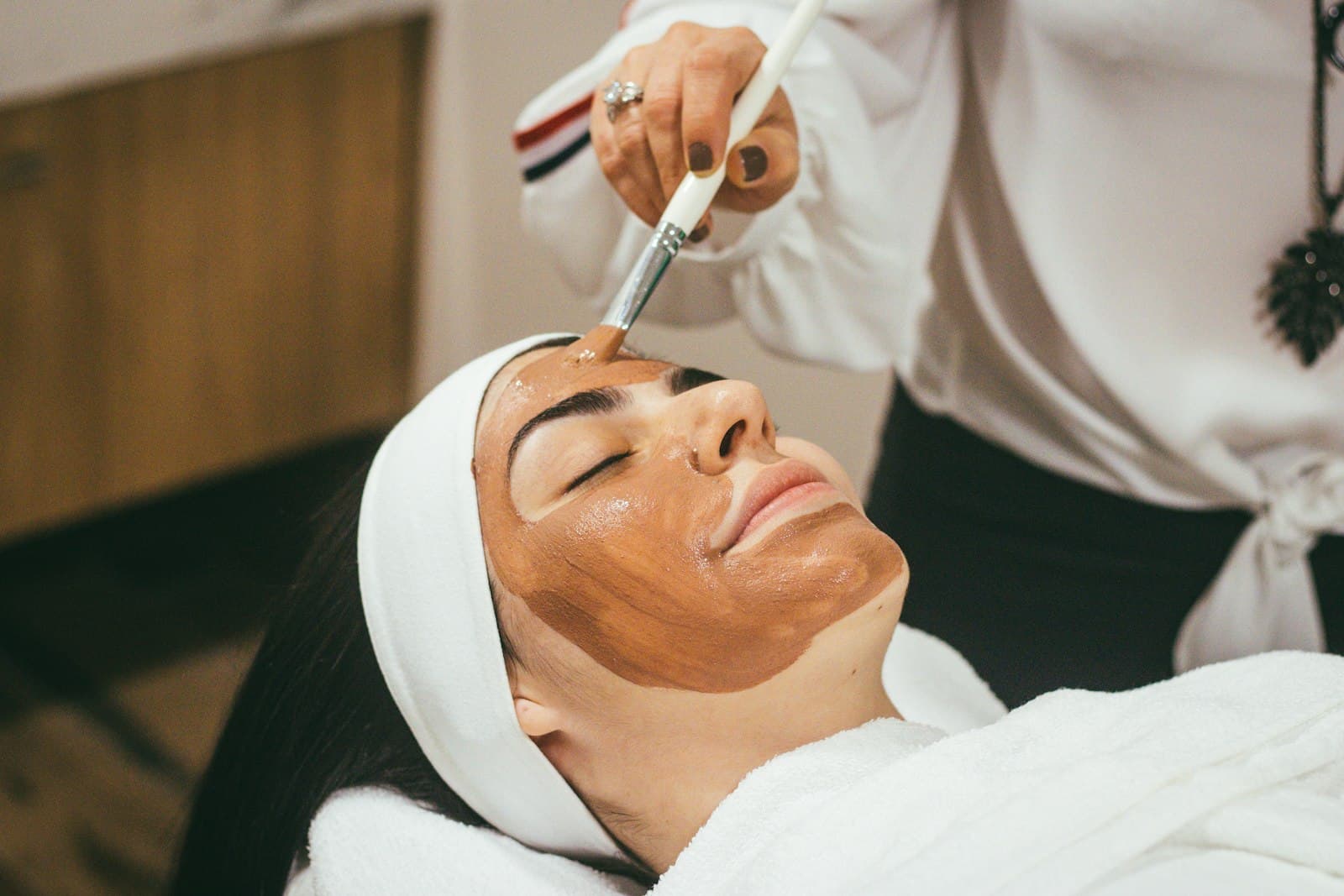 Esthetician performing a facial treatment on a client